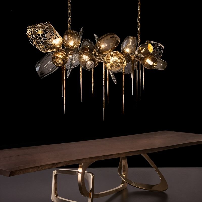 Clérachic linear brass and smoked glass chandelier with spiked drops, lit above a live-edge wooden table on a brass base.