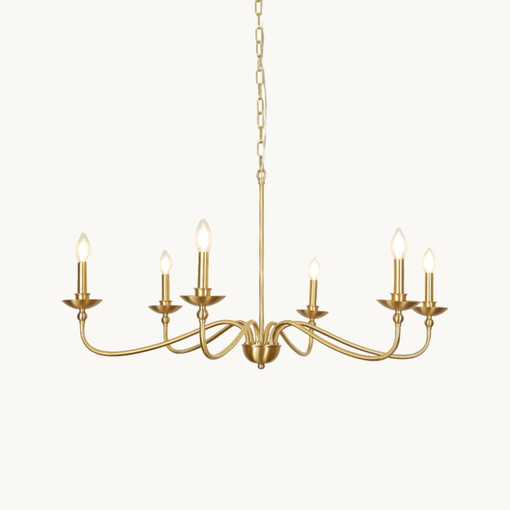 A brass Clérachic chandelier with curved arms and candle-style bulbs, lit on a white backdrop, hung from a slim chain and rod.