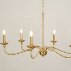 Close view of the lit candle-style bulbs and curved brass arms on this Clérachic chandelier, with the rod above.