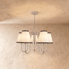 Clérachic chandelier in chrome, five ivory shades with charcoal trim hanging from a slender rod.