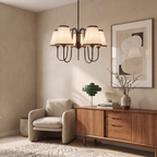 A vintage brass Clérachic chandelier lights a living room corner with an armchair and wood credenza.