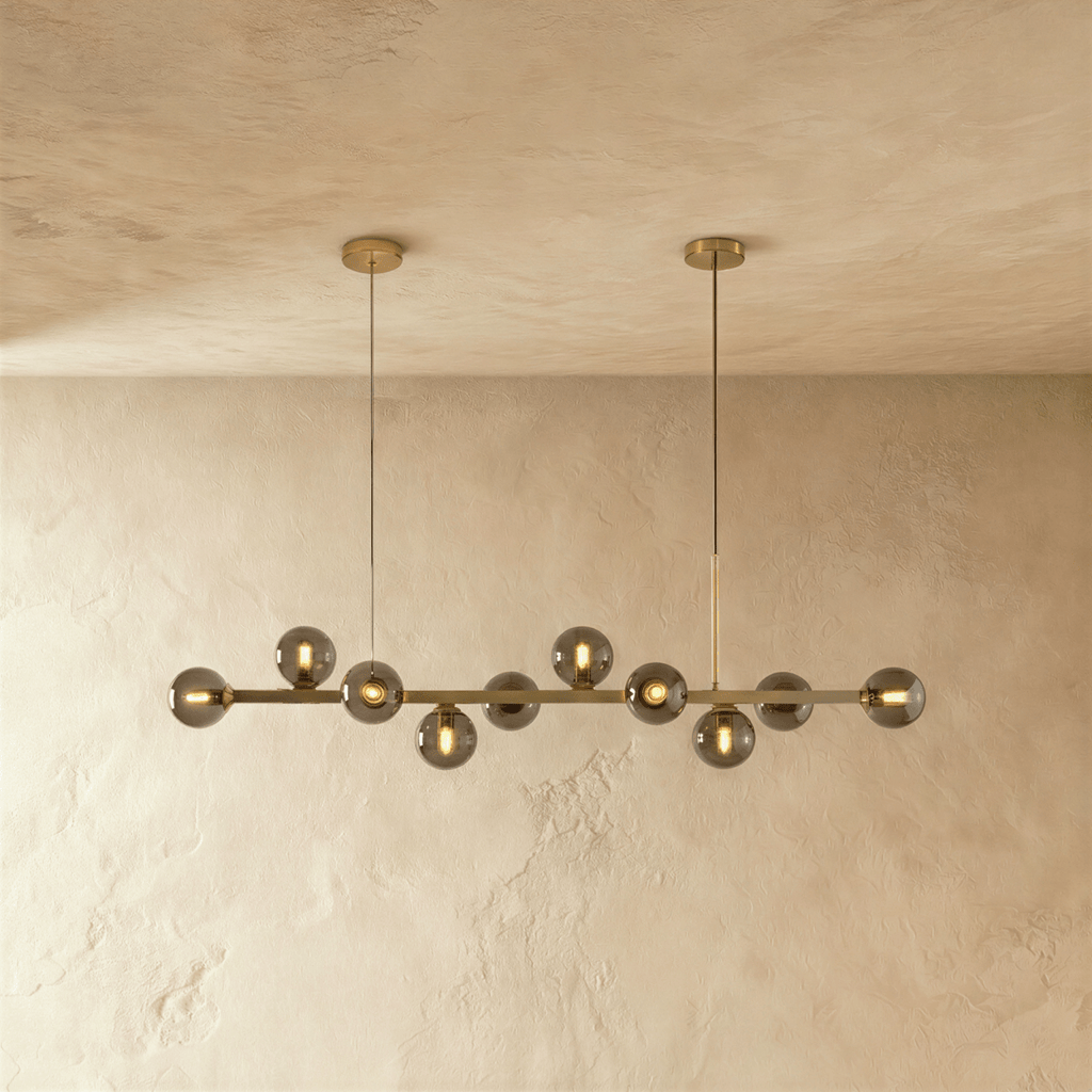 Clérachic brass chandelier glows warm with smokey grey glass globes and bare filament bulbs along its bar.