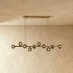 Clérachic brass chandelier with clear glass globes and warm filament bulbs, mounted on a horizontal bar plate.