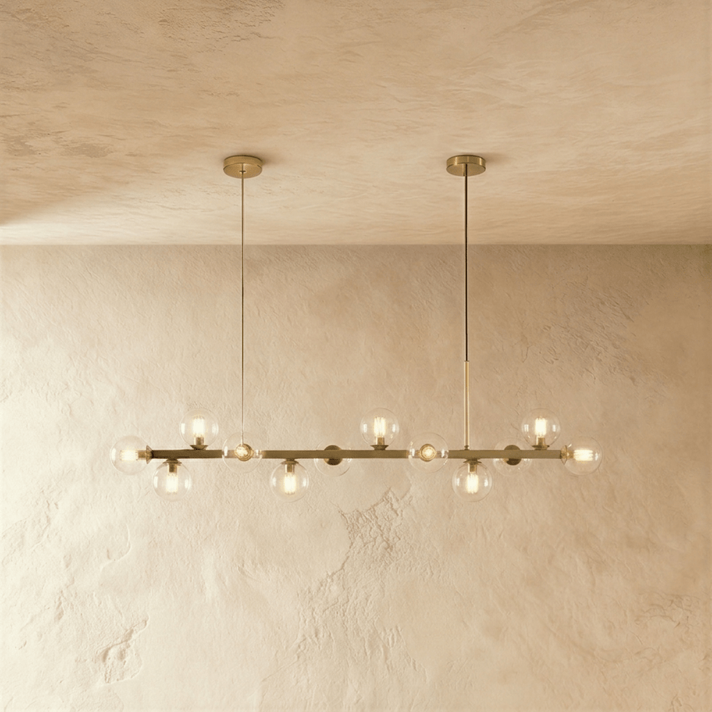 Clérachic chandelier in brass with clear glass globes and glowing filament bulbs on twin round canopies.