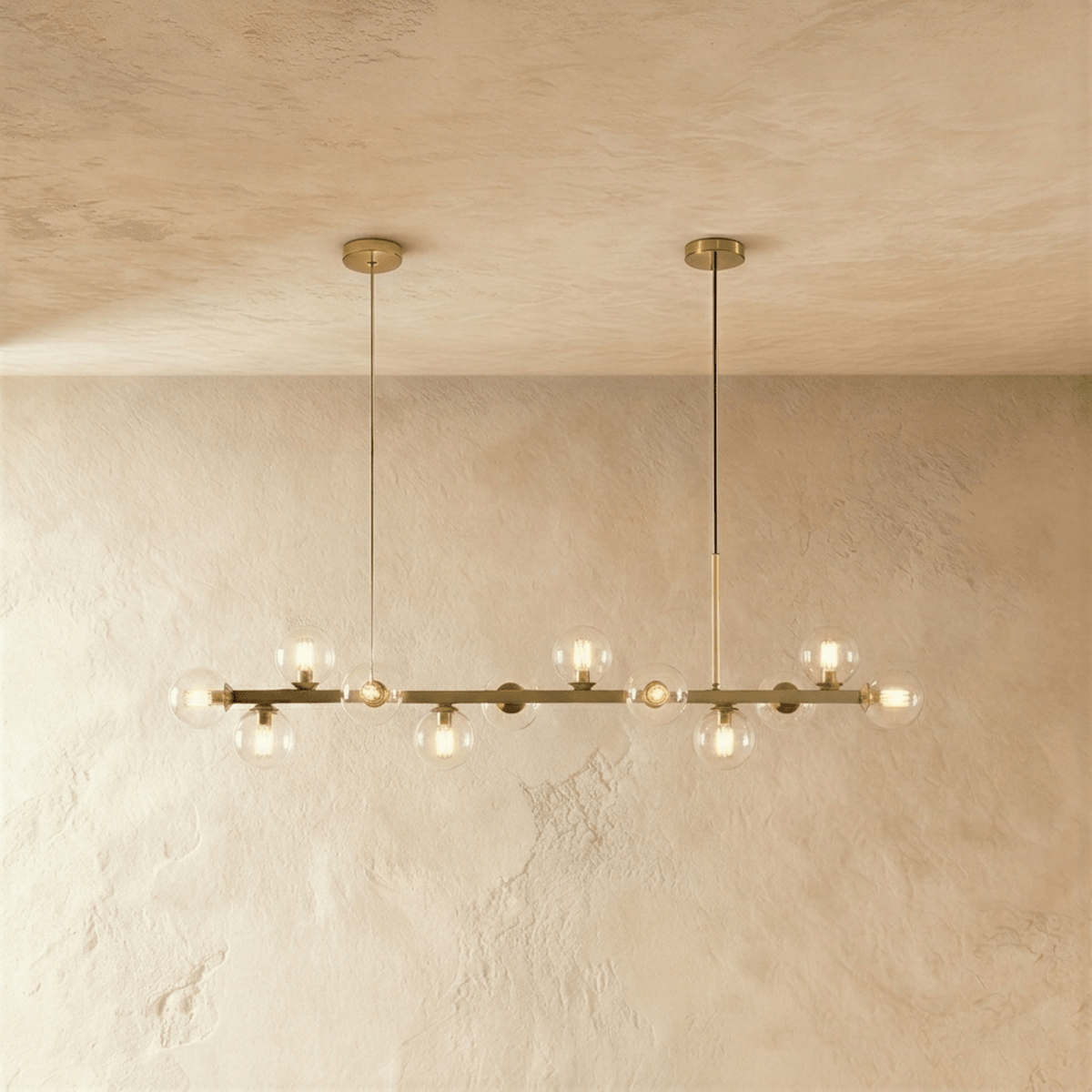 Clérachic chandelier in brass with clear glass globes and glowing filament bulbs on twin round canopies.