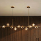 Clérachic chandelier detail shows twin round ceiling canopies and clear glass globes against wood paneling.