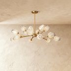 Clérachic brass sputnik chandelier with many frosted faceted glass shades on slim arms, hung against a limewashed ceiling.