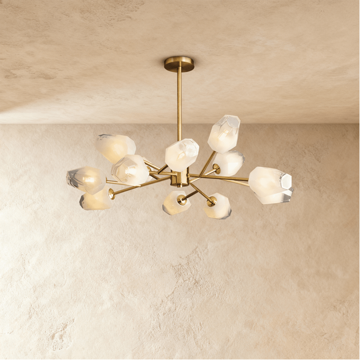 Clérachic twelve-head brass chandelier with frosted faceted glass shades and a slim rod, lit softly against limewash.
