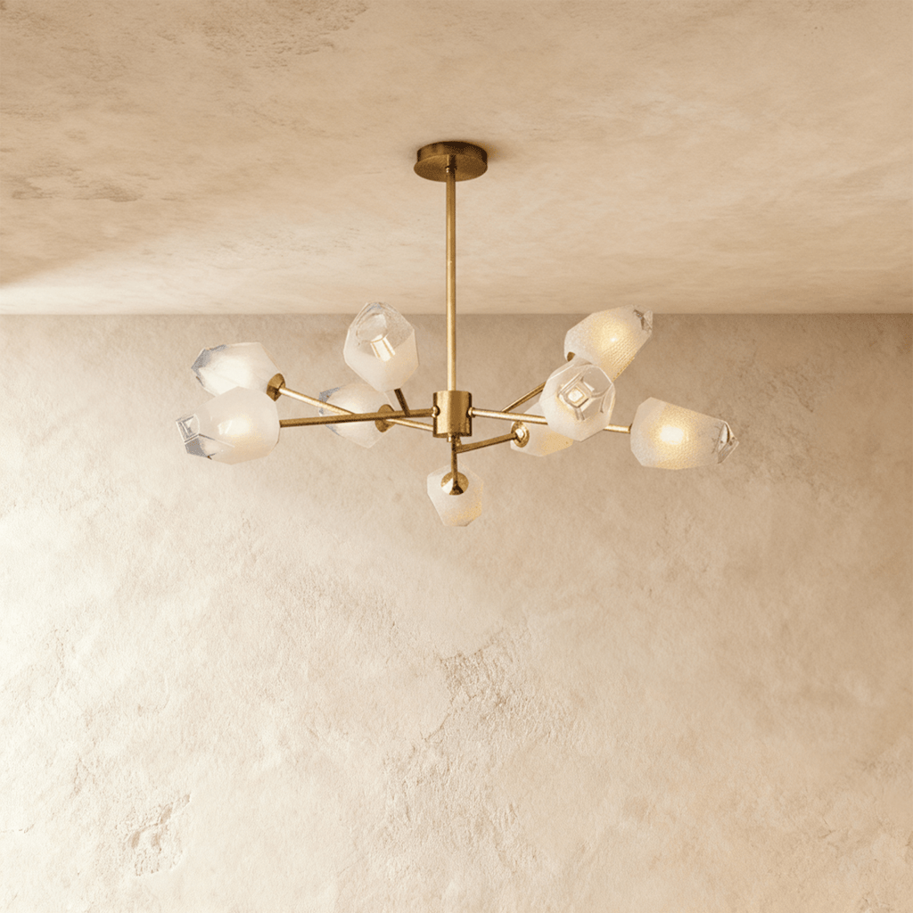 Clérachic nine-head brass chandelier with frosted faceted glass shades on slim arms below a round brass canopy.