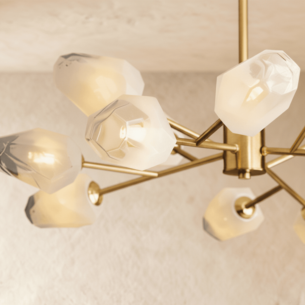 Underside of the Clérachic chandelier showing frosted glass shades with faceted edges and a brass hub with arms.