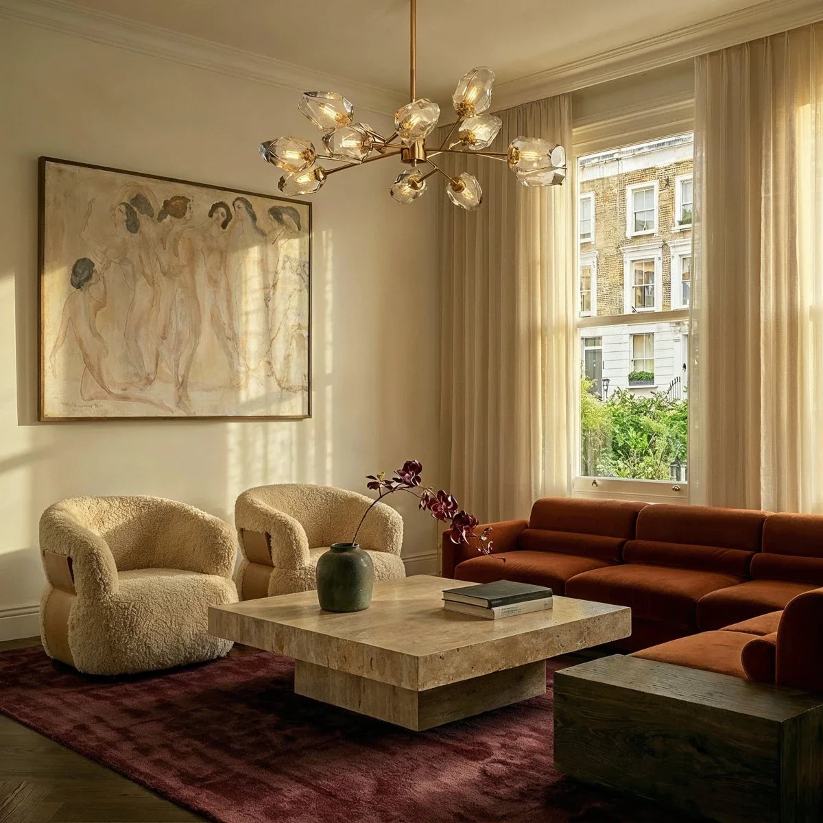 Clérachic brass chandelier with faceted glass heads lit above a travertine coffee table in a sunny living room.