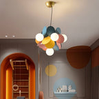 Clérachic small pendant of frosted globes and blue, yellow and pink discs on a black cord, in a playroom.