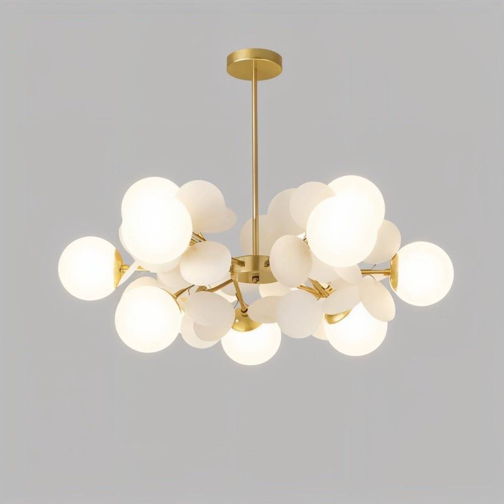 Clérachic brass chandelier with a dense cluster of glowing frosted glass globes and cream discs.