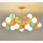 Clérachic wide chandelier of frosted glass globes and mint, orange and yellow metal discs on brass arms.