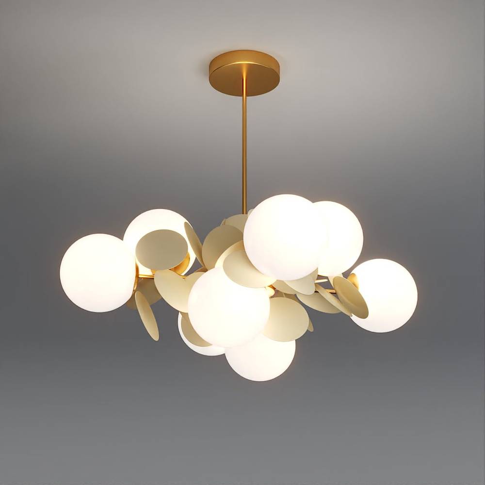 Clérachic brass chandelier lit warm, with frosted glass globes and cream metal discs on a ceiling rod.