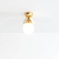 Clérachic single-globe ceiling light with a frosted glass ball, two cream discs and a brass canopy.
