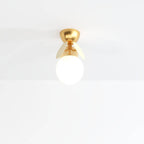 Clérachic single-globe ceiling light with a frosted glass ball, two cream discs and a brass canopy.