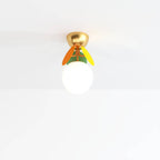 Clérachic single-globe ceiling light: frosted glass ball, orange and yellow discs, green leaf and brass canopy.