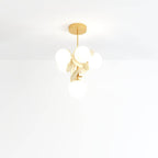 Clérachic tall hanging chandelier of frosted glass globes and cream metal discs on a brass rod and canopy.