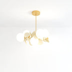 Clérachic chandelier with frosted glass globes and cream metal discs on a brass rod, shot on white.