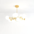 Clérachic wide chandelier of frosted glass globes and cream discs on brass arms, shot on a white ground.
