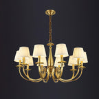 This Clérachic brass chandelier on a dark backdrop, with eight pleated white shades and a baluster stem on a wrapped chain.