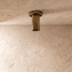 This vintage brass Clérachic ceiling light is shown from below, its round lens glowing softly.