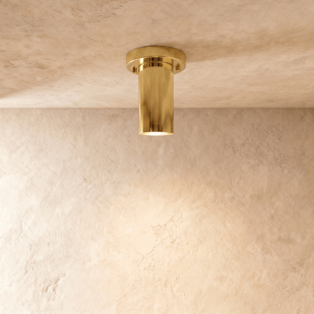 Clérachic ceiling light in polished brass, a slim cylinder flush-mounted against a plaster ceiling.