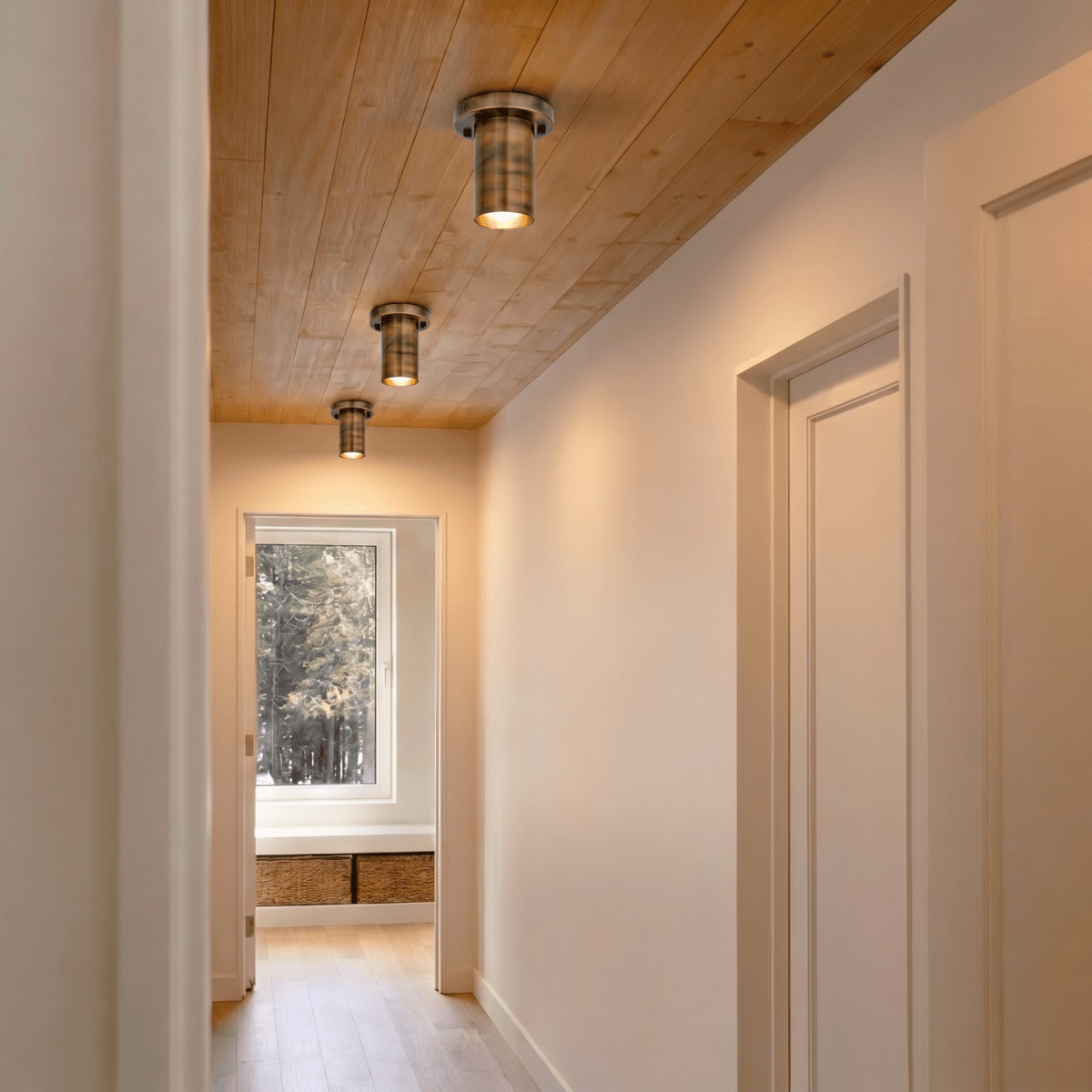 Three vintage brass Clérachic ceiling lights line a wood-paneled hallway leading to a window seat.
