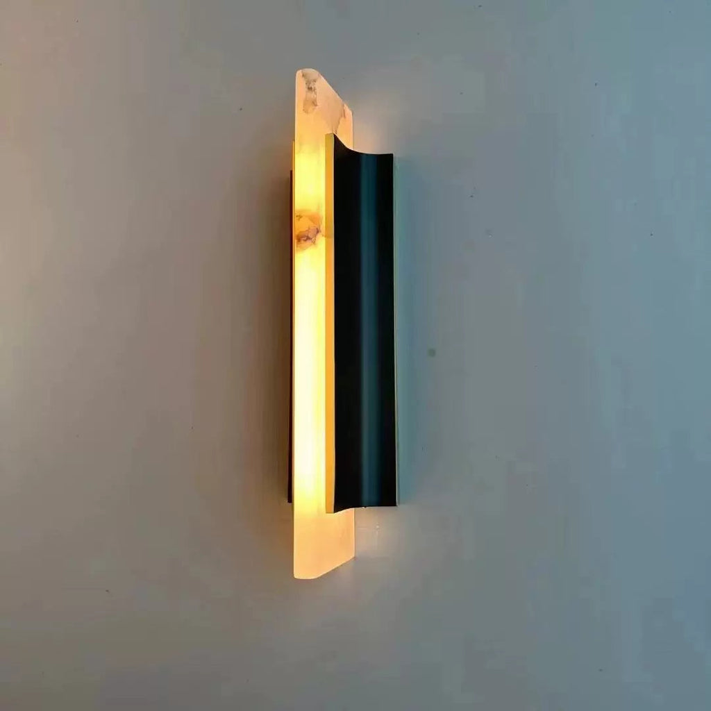 Lit at an angle, the Clérachic Brass-Edged Shield Wall Sconce throws a warm wash up the wall with no bulb anywhere in view.