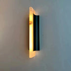 Lit at an angle, the Clérachic Brass-Edged Shield Wall Sconce throws a warm wash up the wall with no bulb anywhere in view.