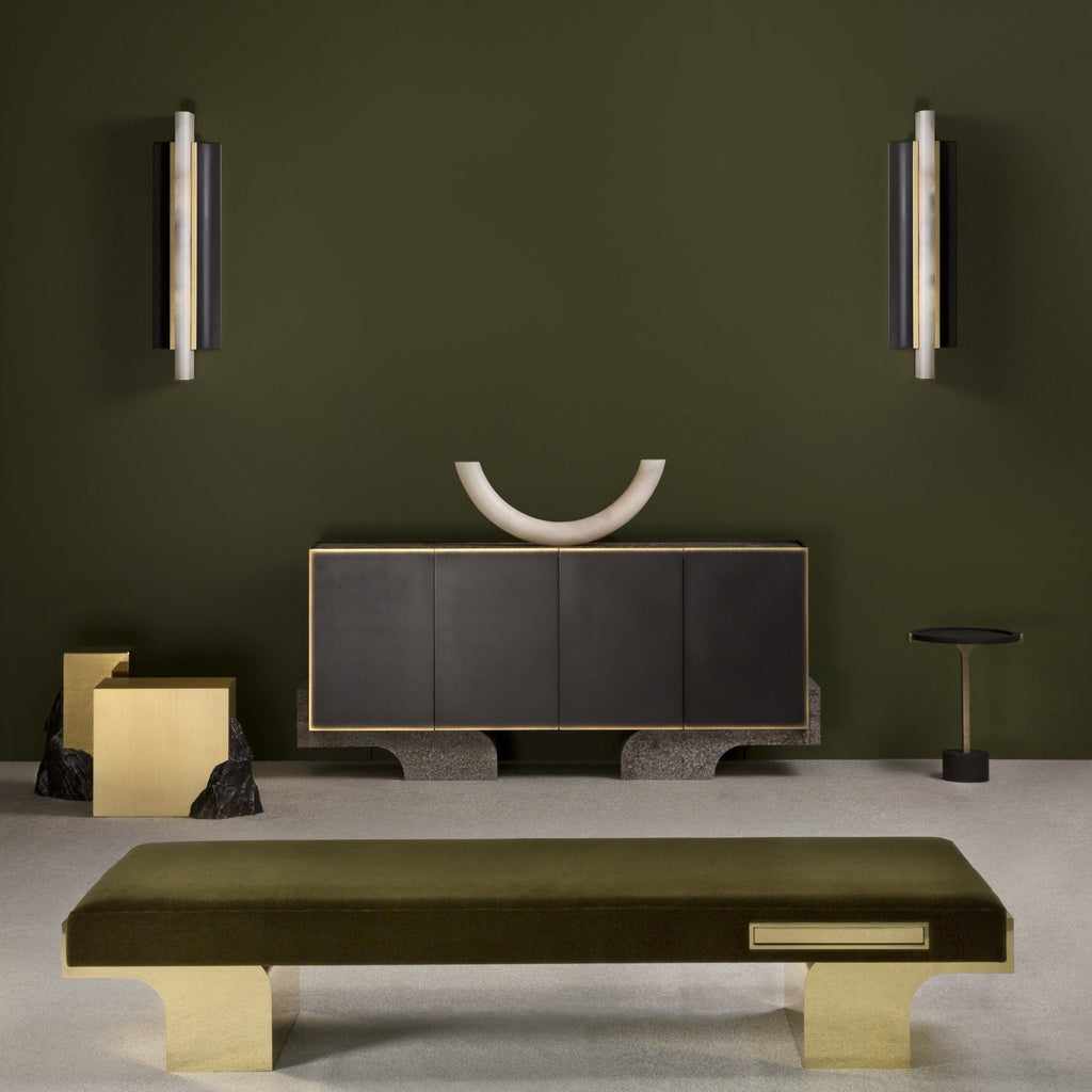 A pair of Clérachic Brass-Edged Shield Wall Sconces mounted either side of a dark sideboard on an olive-green wall.