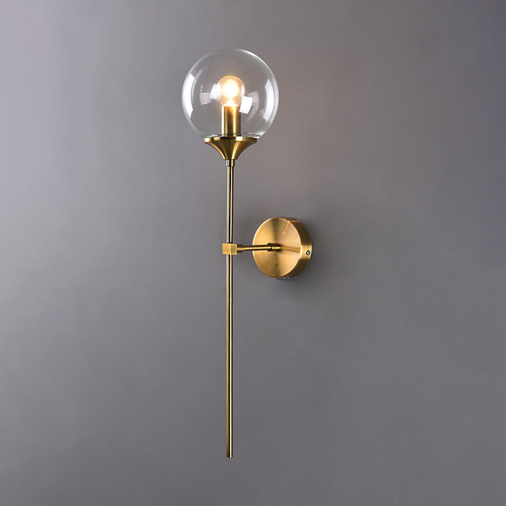 Clear glass version of the Clérachic Brass-Finish Globe Wall Sconce, the bulb fully visible inside the globe on a slim brass stem.