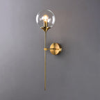 Clear glass version of the Clérachic Brass-Finish Globe Wall Sconce, the bulb fully visible inside the globe on a slim brass stem.