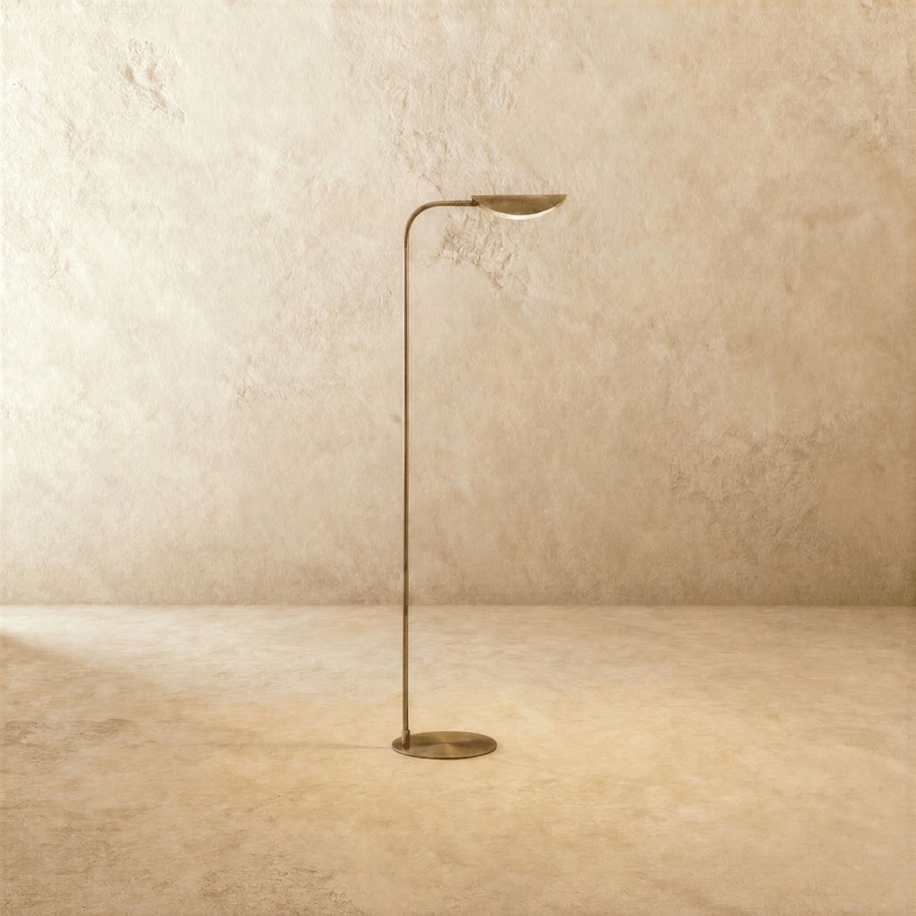 Clérachic floor lamp in vintage brass with a leaf-shaped shade tilted upward on a slender curved rod.
