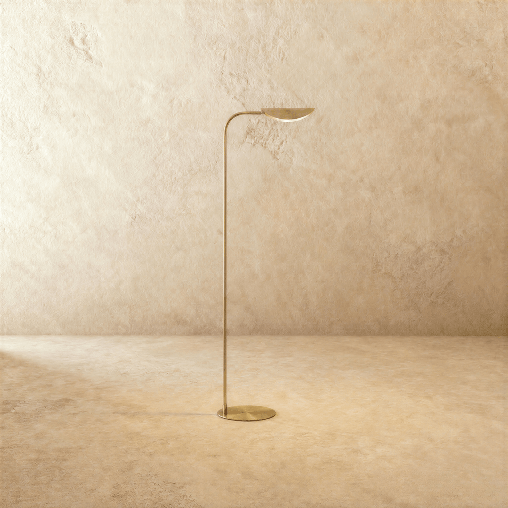 Clérachic floor lamp in polished brass, its leaf-shaped shade rising from a slim curved rod and round base.