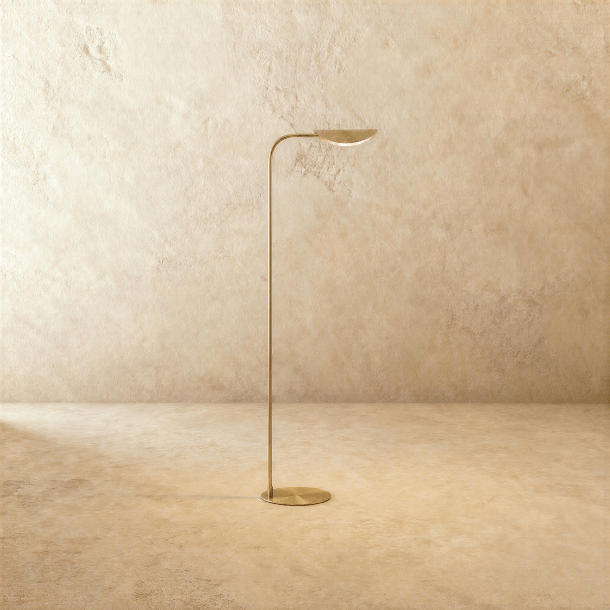Clérachic floor lamp in polished brass, its leaf-shaped shade rising from a slim curved rod and round base.