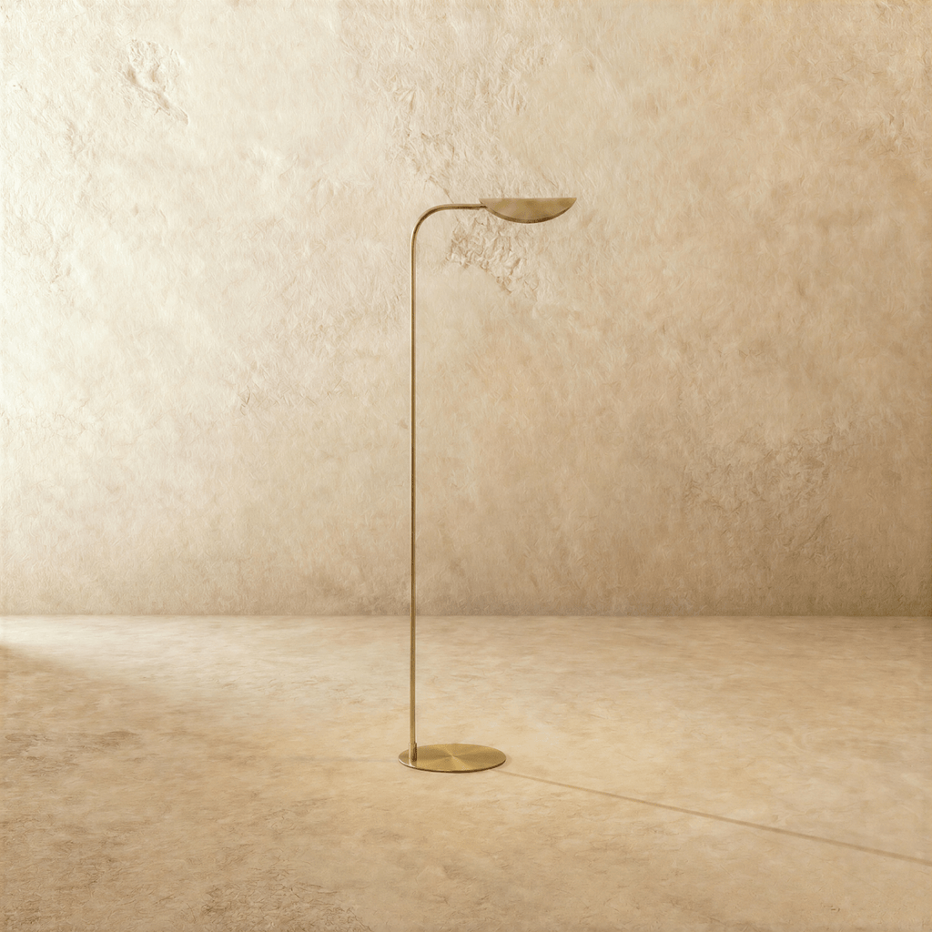 This polished brass Clérachic floor lamp is shown from a different angle, the leaf shade tilted upward.