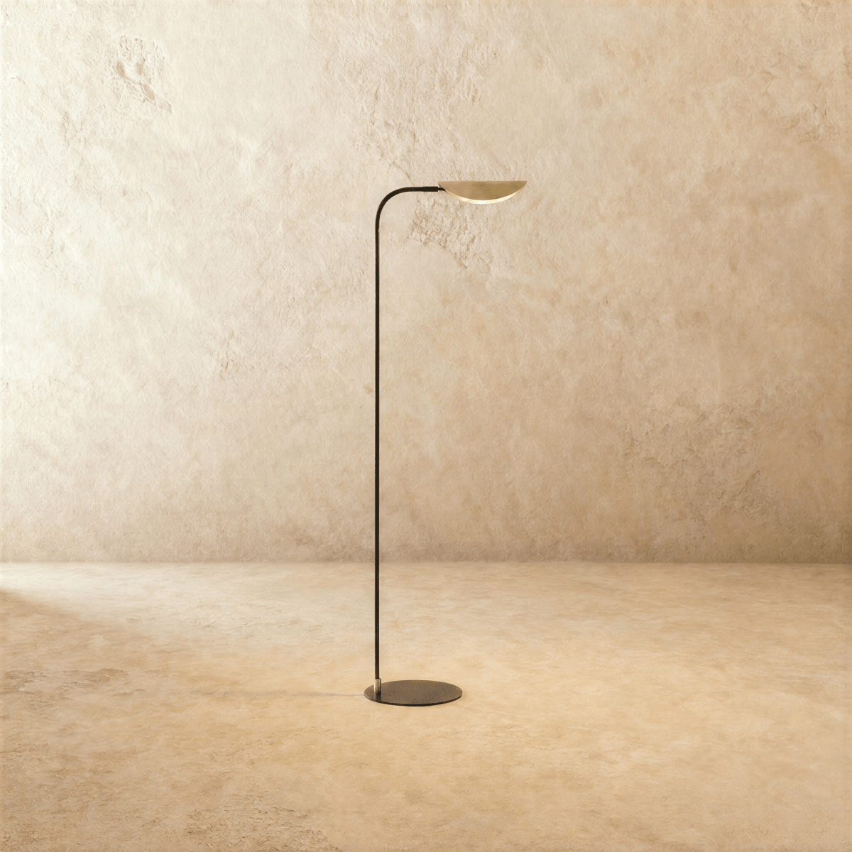 Clérachic floor lamp in brass and black, its brass leaf shade angled upward on a matte black rod.