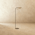 This brass-and-black Clérachic floor lamp is shown from another angle, the shade tilted toward the ceiling.