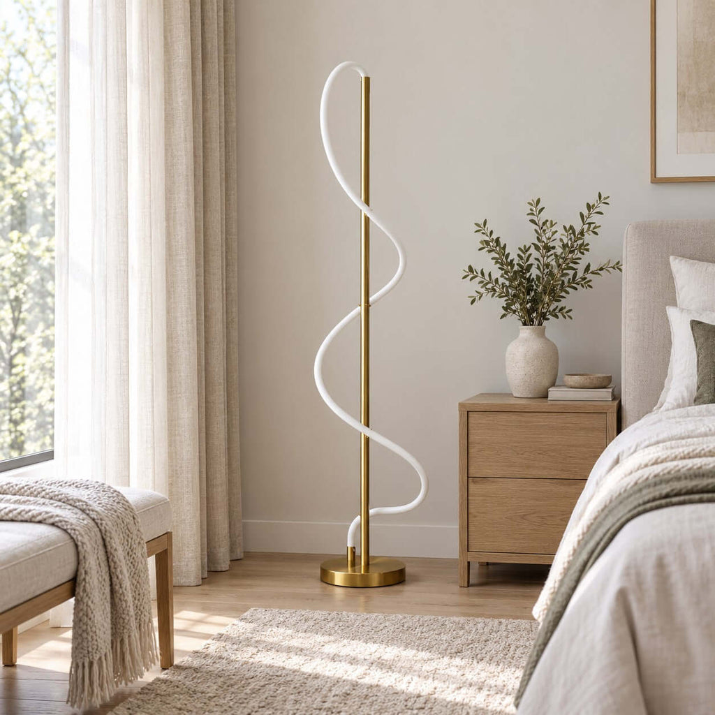 Unlit in a bedroom with a pale wood nightstand and a throw on a bench, this Clérachic floor lamp shows its soft white silicone coil.