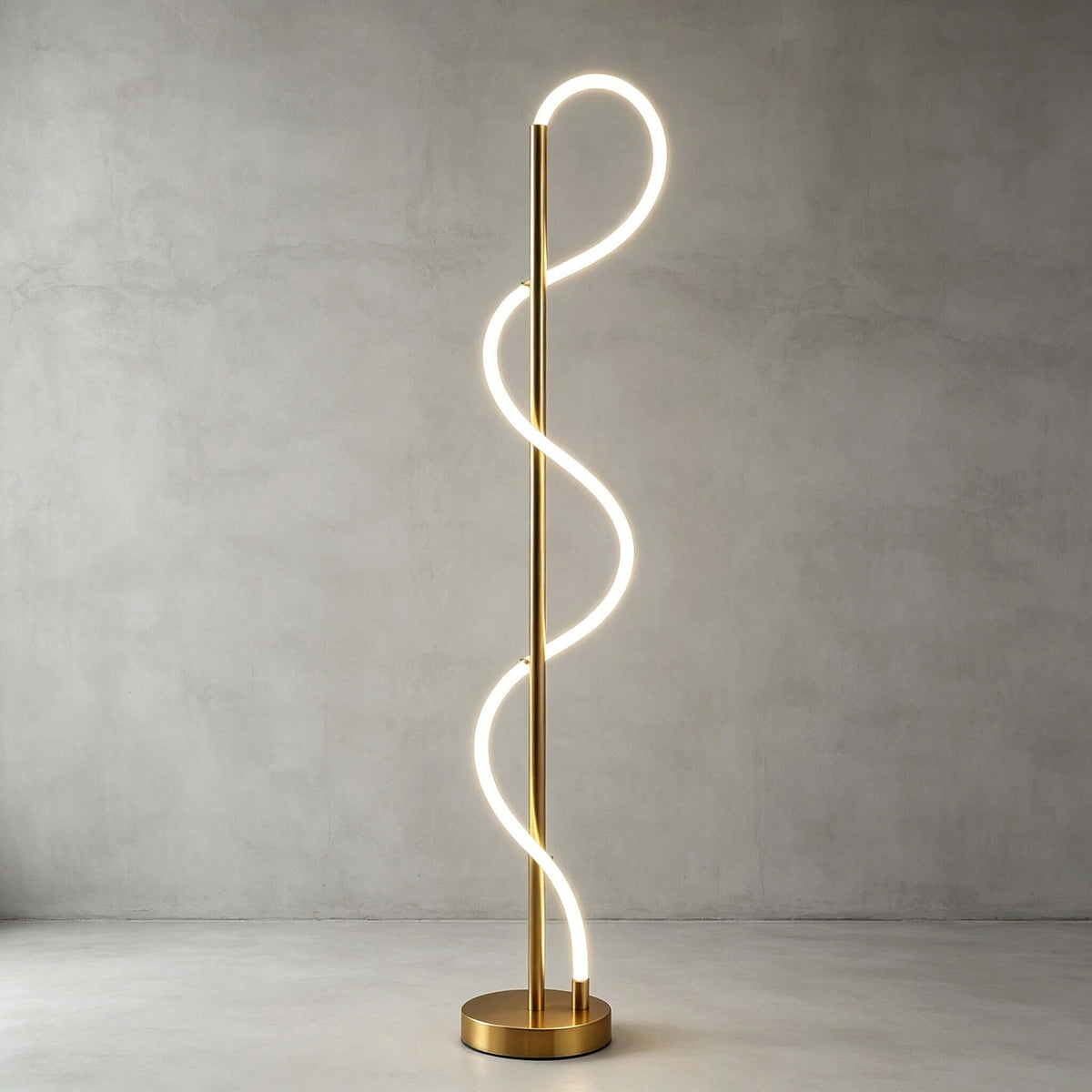 Bright white light glows along the looping silicone strip of this Clérachic floor lamp, on a brass base against a grey concrete wall.