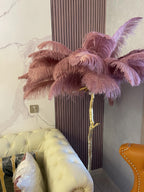 Dusty mauve plumes on a Clérachic floor lamp rise beside a ribbed wall panel and a cream tufted sofa.