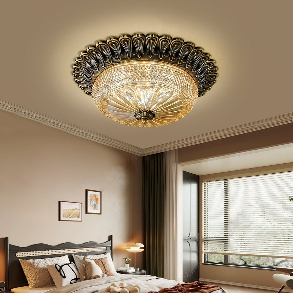 Warm-lit Clérachic flush mount ceiling light over a bedroom with a scalloped headboard, a window with blinds and a rust throw on the bed.