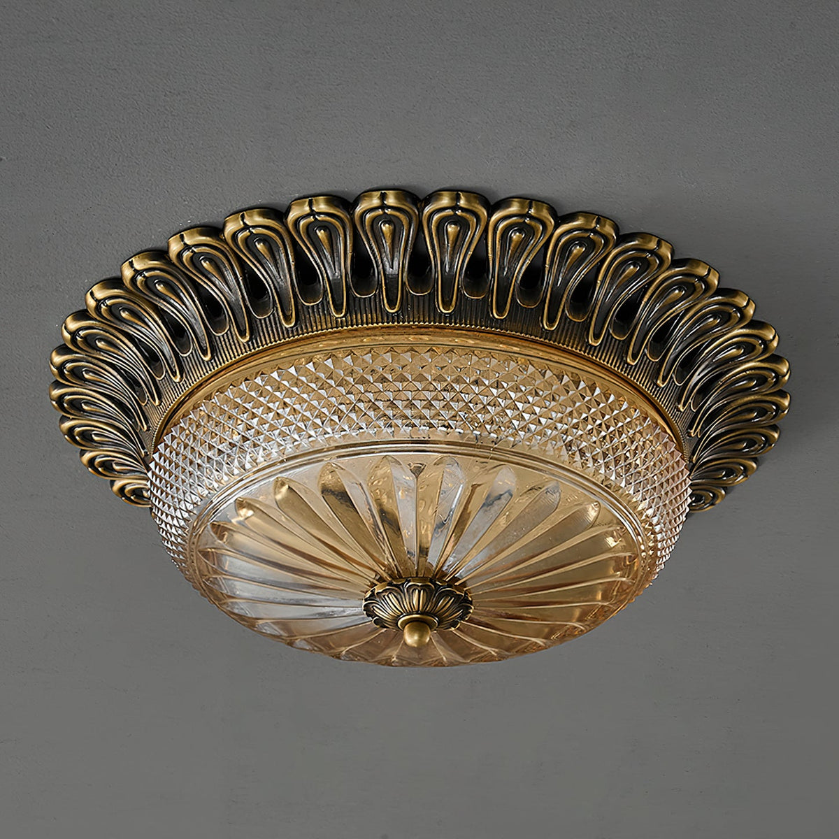 Underside view of this Clérachic ceiling light on grey, showing the ribbed amber glass and the brass finial at the centre.