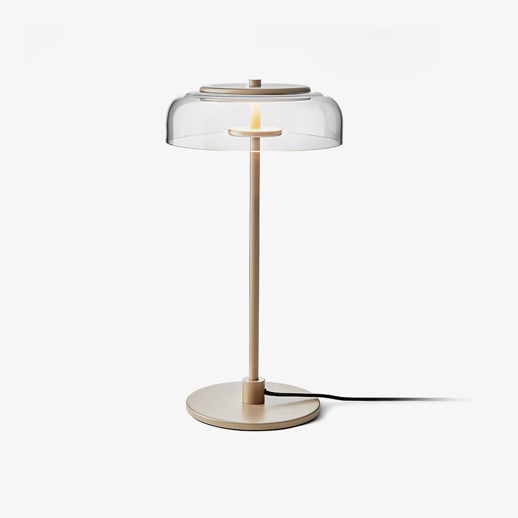 This Clérachic table lamp on a plain white backdrop, with a clear glass dome, a slim brass-toned stem and a round base with a black cord.