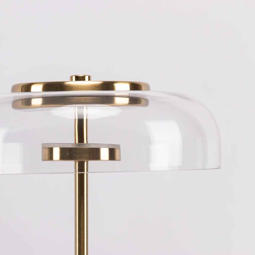 Close view of the unlit glass dome with its brass cap and the small brass disc that holds the LED in this Clérachic table lamp.
