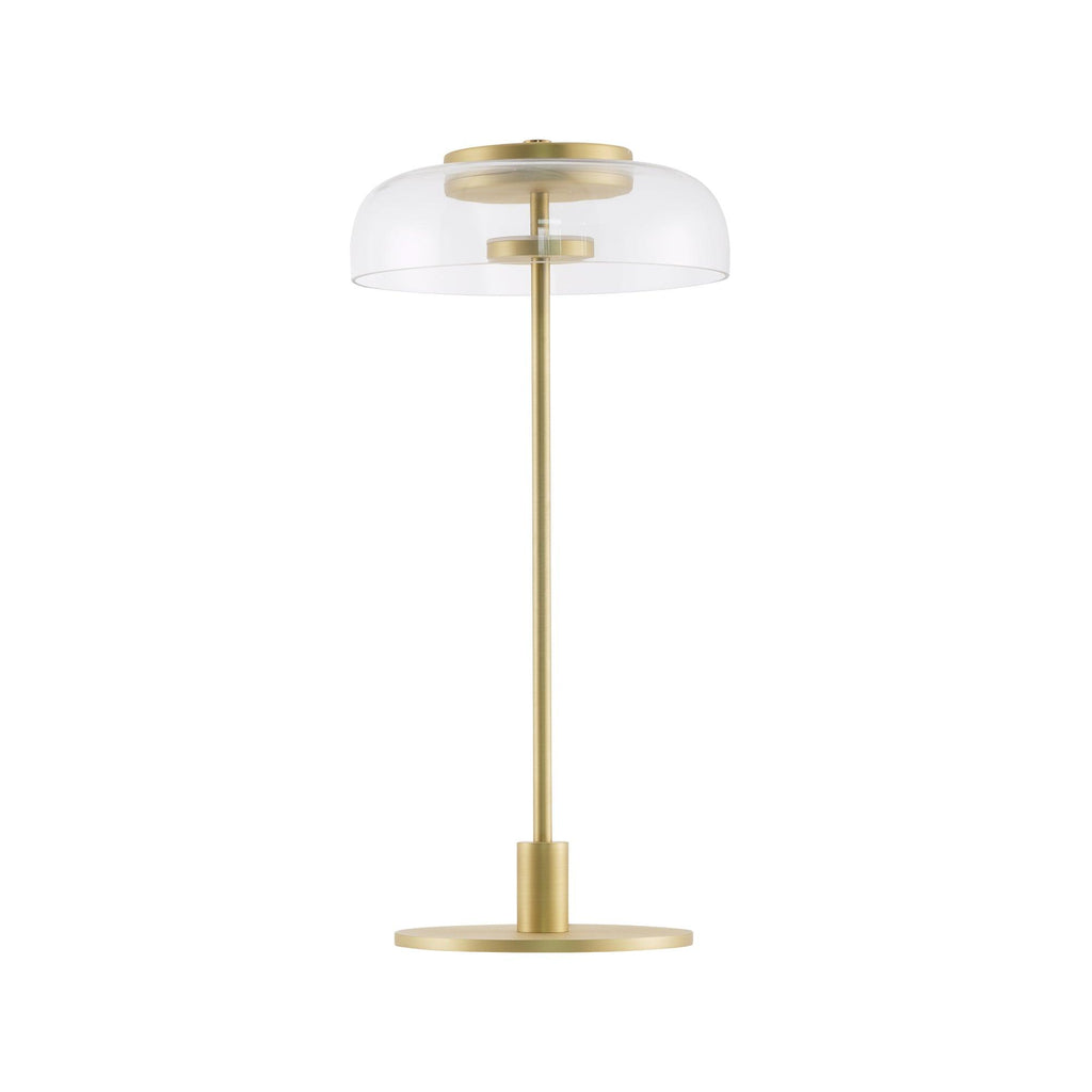A Clérachic table lamp with a clear glass dome, shown unlit on a white background, standing on a slim brass stem and a flat round base.