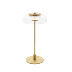 A Clérachic table lamp on a white background, with a clear dome, a brass cap and a brass stem on a solid round base.