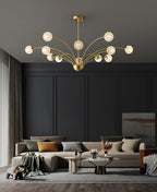 A Clérachic chandelier with warm textured globes over a low sofa in a charcoal living room with panelled walls and a rug.